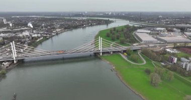 Almanya, Duisburg 'daki Ren Nehri üzerinde trafik altyapısı, su yolu ve karayolu geçişine odaklanan bir köprünün insansız hava aracı videosu..