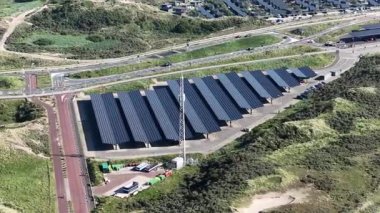 Elektrikli araç güneş panelleri ve otopark birleşimiyle şarj oluyor. EV altyapısı. Bloemendaal, Hollanda. Hava aracı görünümü.