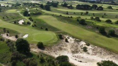 Kennedy Golf ve Golf Kulübü, Zandvoort 'taki kum tepelerinde golf sahası. Spor ve eğlence sektörü. Hava aracı videosu.