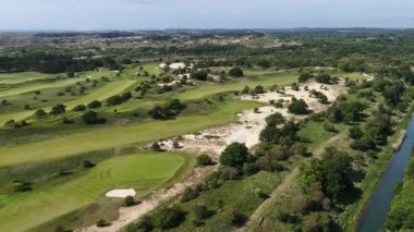 Kennedy Golf ve Golf Kulübü, Zandvoort 'taki kum tepelerinde golf sahası. Spor ve eğlence sektörü. Hava aracı videosu.