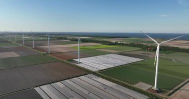 Simetrik tarım alanlarındaki rüzgar türbinleri, tarım arazileri, temiz yeşil enerji. Hava aracı görünümü.