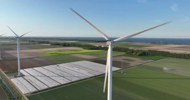 Simetrik tarım alanlarındaki rüzgar türbinleri, tarım arazileri, temiz yeşil enerji. Hava aracı görünümü.