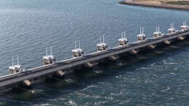 Delta Neeltje Jans, Oosterscheldekering, fırtına dalgalanma bariyeri, Zeeland, Hollanda 'da çalışır. Hava aracı videosu.