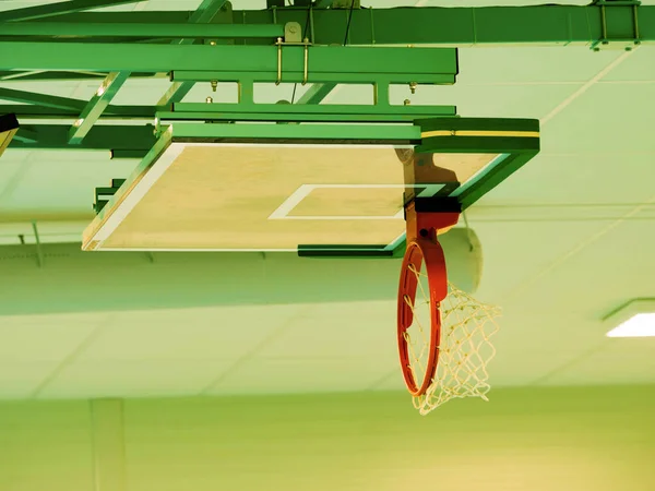 折叠式篮板和篮筐边风箱天花板 学校体育馆屋顶下的红金属环和白网 — 图库照片