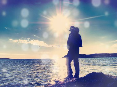 Fisherman check pushing bait on the fishing line, throw lure into blue water