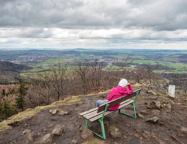 穿着粉色保暖夹克坐在路西天山顶长椅上的观光客女子有罪 德国上空乌云密布的雪天 — 图库照片