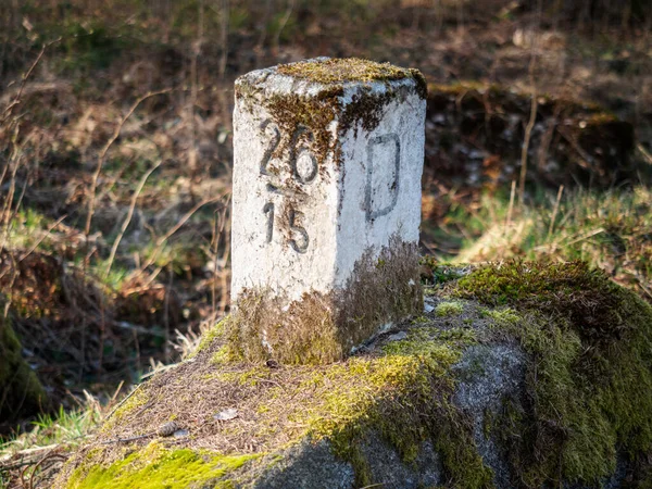 stock image German Czech republic border stone graved in the bigger stone, brown dry moss covered it