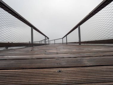 Ağaç tepelerinde yol. Tekerlekli sandalyeler için tahta kalaslar. Tahta ve tel bariyer ziyaretçiler için serbest yol.