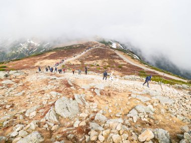 SNEZKA, Dev Dağlar - 30 Nisan 2023. Krkonose Ulusal Parkı 'nda Snezka' da sis altında bir grup insan. Hava çok kötü..