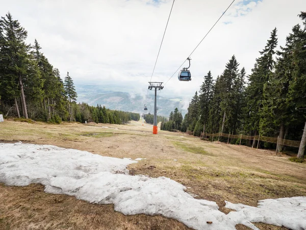 草の多いスキー場の上のキャビンは 観光客と一緒に丘に移動します スノーボーダーやスキーヤーのために — ストック写真