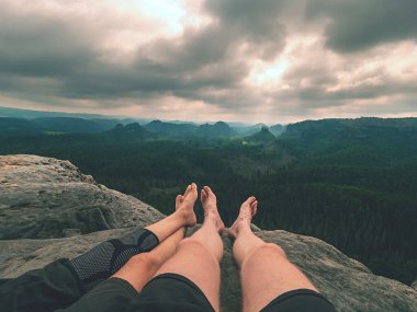 Dağlarda ayakkabısız yürüyüş yapmaktan yorulduk. Heteroseksüel çiftlerin yalın ayakları. Doğa parkının dağlık arazisindeki uzun orman vadisi.