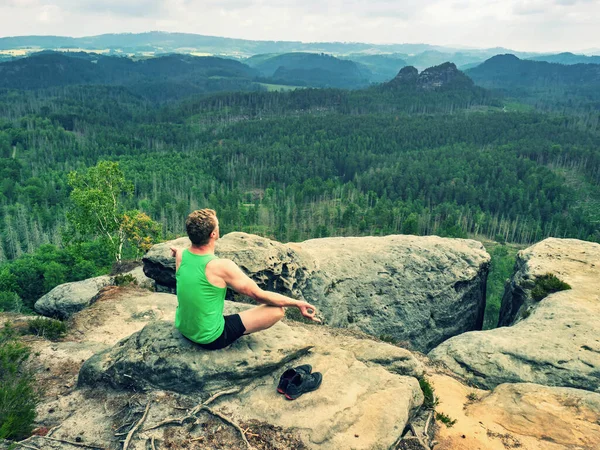 男人以瑜伽姿势坐在山顶上 带着令人叹为观止的观点 在边缘练习瑜伽 灵魂与自然的融合 — 图库照片