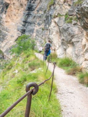 Sert dolomit kireç taşına bağlanmış halat ve prangalar. Ferrata üzerinden tırmanma yolu. Demir zincir ve ipler blokta sabitlendi. Alplerdeki gibi dağların zirvesine giden yol. Ölü dağcıların anıtı.