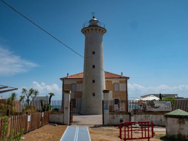 25 Temmuz 2023, Faro di Punta Tagliamento, Bibione, İtalya. 1913 'te inşa edilmiş, beton kulesi ve sakin bir plajın etkin ışığı olan popüler beyaz deniz feneri..
