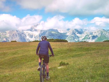 Genç çocuk dağ bisikletine binip Alplerden Lago di Garda Vadisi 'ne kadar izliyor. Dolomite Alpleri, Trento bölgesi, İtalya 