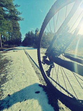 Karda arka bisiklet tekerleği. Detaylı olarak düşük ayak bileği görüntüsü. Karlı manzarada dosyalanmış
