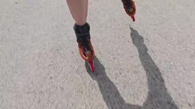 Turuncu çizmeli erkek bacakları yakından görülüyor. Çizmeler yolda ilerliyor.. 