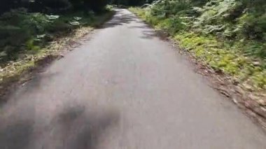 Çizmeli bacaklar ormanda terk edilmiş asfalt yolda ilerliyor.. 