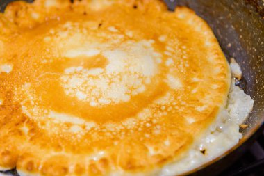 Tavada Amerikan gözlemesi yanığı, mutfakta ev yapımı krep. Gaz ocağında tavada leziz ince bir krep. Yakın çekim..