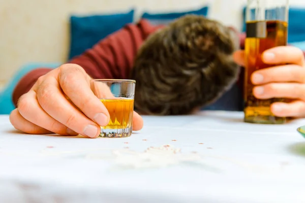 不受控制的饮酒 酒精中毒 酒瓶和玻璃杯的闭塞 无节制饮酒的概念 在家里喝醉酒的人 有选择地集中精神 — 图库照片