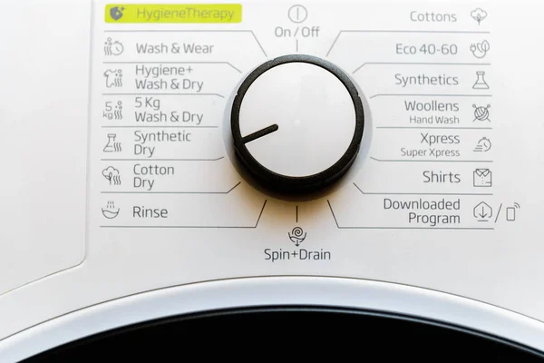 White clothes dryer washing machine dial control panel with rotation knob and various program names in Dutch.