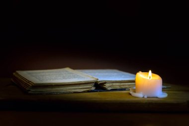 Dini kavram. İncil ve mum eski ahşap bir masa üzerinde. Güzel altın arka plan. Güzel, hoş din kavramı..