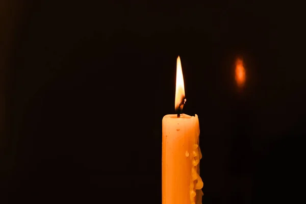 在黑暗中点燃一支蜡烛 关上黑色背景上的单个烛光和火焰 熔融蜡烛光边框设计 夜晚燃烧 复制空间 — 图库照片
