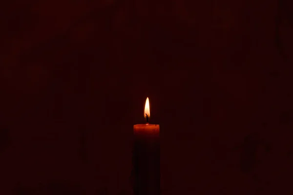 在黑暗中点燃一支蜡烛 关上黑色背景上的单个烛光和火焰 熔融蜡烛光边框设计 夜晚燃烧 复制空间 — 图库照片#