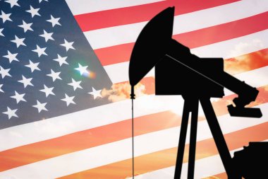 ABD bayrağının arka planında petrol sondajı yapan siyah bir pompa silueti..