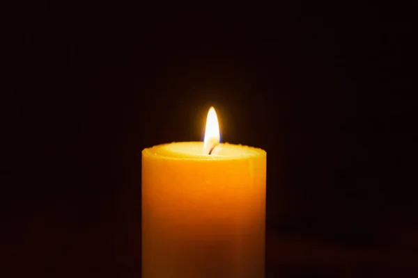 Candle flame on a dark background, symbol of prayer and remembrance.Religion concept.