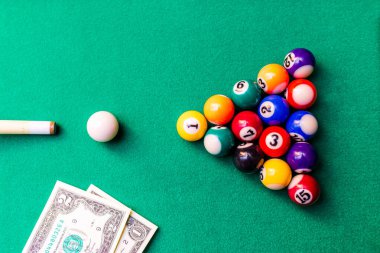 Kumar tutkusu. Para ve sayılı çok renkli bilardo topları. Oyun masasının üzerine dolar banknotları..