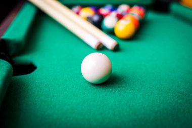 Bilardo sporu kavramı. Bilardo oynamak. Bilardo ıstakaları ve yeşil bilardo masasında çok renkli bilardo topu piramidi..