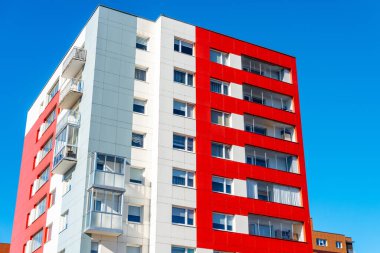 Satılık daireleri olan yeni yapılmış parlak renkli bir bina. Kırmızı turuncu ve yeşil apartman blokları. Yeni yenilenmiş konut alanında yeni bitirilmiş modern tarz apartman..