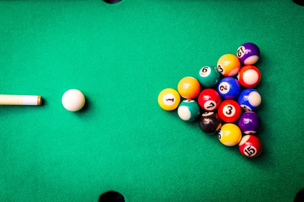 stock image Billiard balls on the green table with billiard cue, Snooker,Pool game.Cue aim billiard snooker pyramid on green table.Top view.Billiard sport concept.