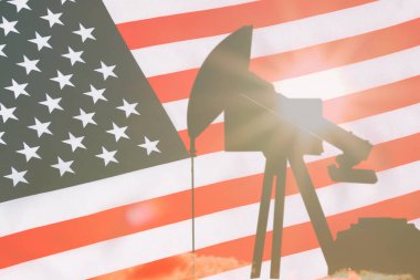 ABD bayrağının arka planında petrol sondajı yapan siyah bir pompa silueti..