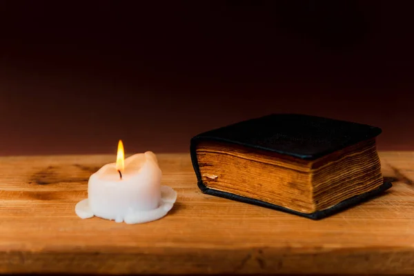 Religious concept.Holy Bible and candle on a old wooden table.Beautiful gold background.Beautiful,pleasant Religion concept.Copy space.