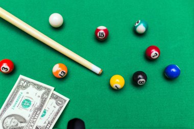 Kumar tutkusu. Para ve sayılı çok renkli bilardo topları. Oyun masasının üzerine dolar banknotları..