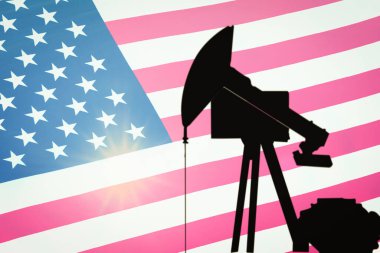 ABD bayrağının arka planında petrol sondajı yapan siyah bir pompa silueti..