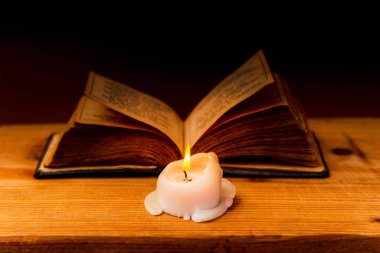 Dini kavram. İncil ve mum eski ahşap bir masa üzerinde. Güzel altın arka plan..