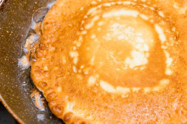 Tavada Amerikan gözlemesi yanığı, mutfakta ev yapımı krep. Gaz ocağında tavada leziz ince bir krep. Yakın çekim..