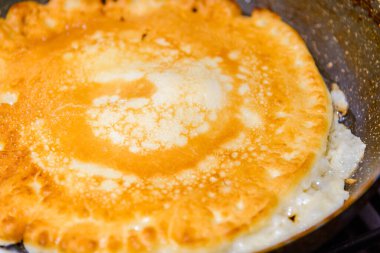 Tavada Amerikan gözlemesi yanığı, mutfakta ev yapımı krep. Gaz ocağında tavada leziz ince bir krep. Yakın çekim..