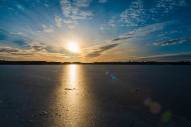 Kışın buzla kaplı güzel bir göl. Gün batımında güzel bir akşam..