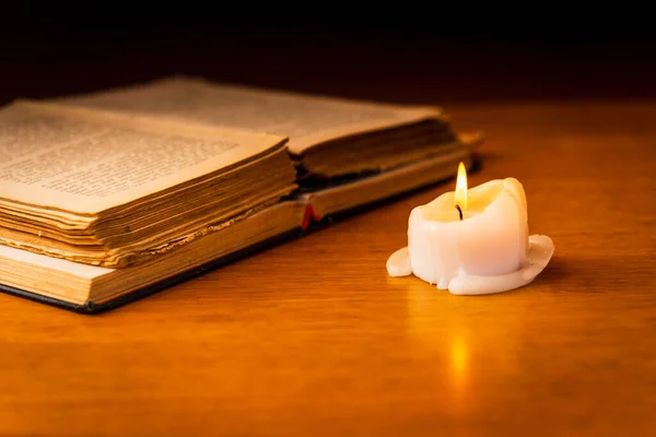 Religious concept.Bible and candle on a old wooden table.Beautiful gold background.Beautiful,pleasant Religion concept.
