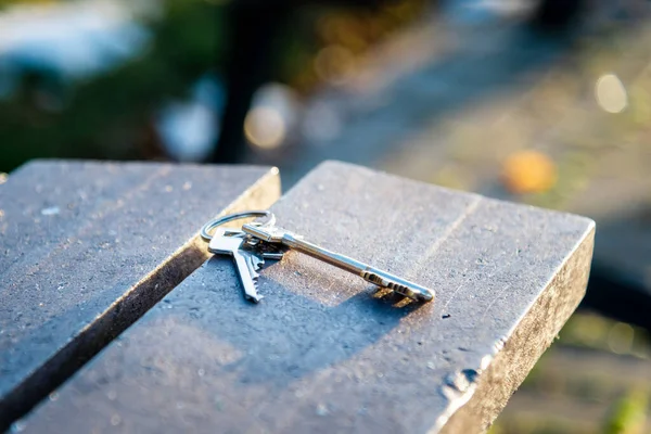 Lost keys to the house lie on a wooden bench. forgotten keys lie the bench.You won\'t go home if you lose your keys.Selective focus.