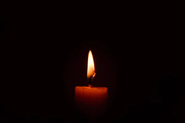 在黑暗中点燃一支蜡烛 关上黑色背景上的单个烛光和火焰 熔融蜡烛光边框设计 夜晚燃烧 复制空间 — 图库照片