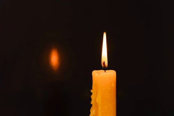 stock image One light candle burning brightly in the dark background.Copy space.