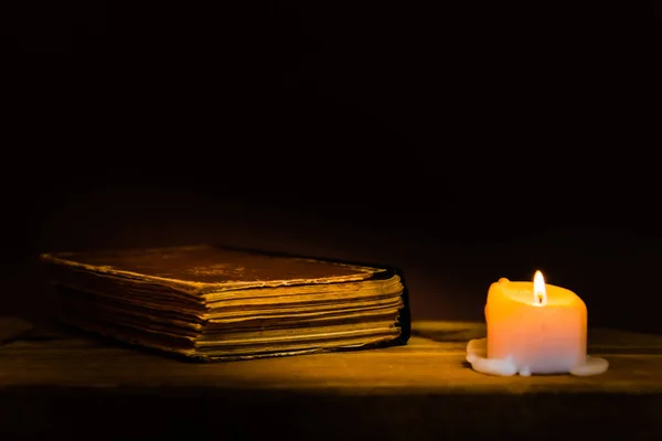 Religious concept.Bible and candle on a old wooden table.Beautiful gold background.Beautiful,pleasant Religion concept.