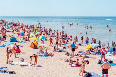 Deniz kenarındaki kalabalık plaj güneşli bir gün, kalabalık. Mavi gökyüzü sıcak yaz günü. Palanga-Litvanya, 27-2020.