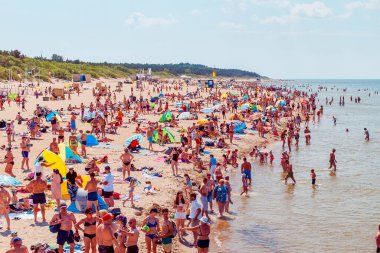 Deniz kenarındaki kalabalık plaj güneşli bir gün, kalabalık. Mavi gökyüzü sıcak yaz günü. Palanga-Litvanya, 27-2020.