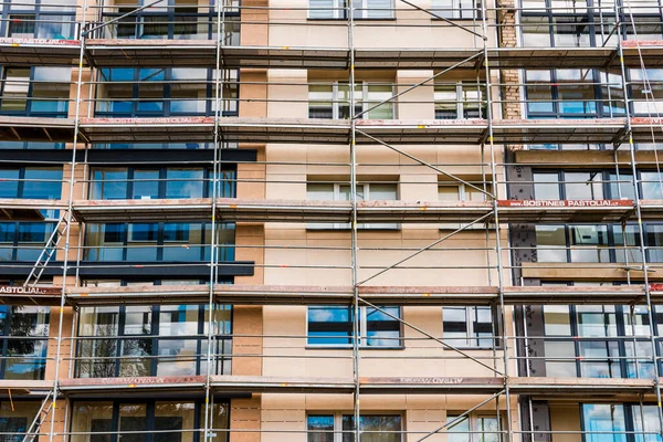 İnşaat iskelesi yenileme alanı. İnşaat alanının önündeki binanın dış görünüşü. Telsiai, Litvanya. 04-30-2023..